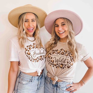 Op de afbeelding: Twee vrouwen dragen T-shirts met een luipaardprint. E&eacute;n shirt zegt "Born to be Bridal" en de andere zegt "Born to be Wild".