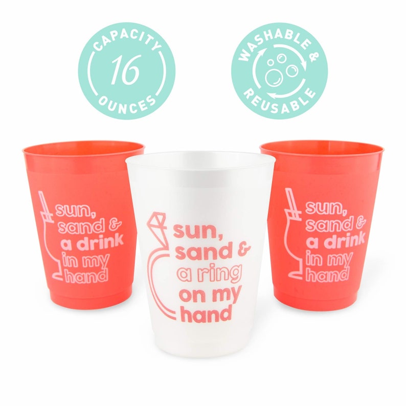 May include: Three plastic cups, two in coral and one in white. The coral cups have the text "sun, sand & a drink in my hand." The white cup has the text "sun, sand & a ring on my hand." Each cup has a 16-ounce capacity.