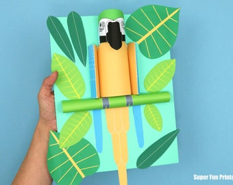 May include: A paper craft parrot with blue, green, and yellow feathers perched on a green branch. The parrot is surrounded by green leaves on a light blue background. The craft is made with paper and is a fun activity for kids.