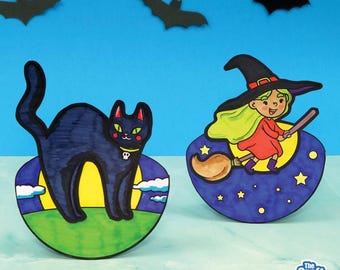 May include: Two Halloween-themed paper cutouts. One is a black cat with yellow eyes and a skull collar, set against a yellow moon and green grass. The other is a witch riding a broom, with a red dress and green hair, on a purple background with stars.