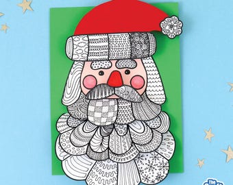 May include: A handmade Santa Claus card with a red hat, a pink nose and cheeks, and a white beard. The beard and hat are decorated with intricate black and white patterns. The card is on a green background with a blue backdrop and gold star decorations.