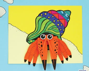May include: A colorful paper craft of a hermit crab with a patterned shell and orange body. The crab is set against a yellow background with a sandy beach design. The image includes the text "SUPER FUN PRINTABLES".