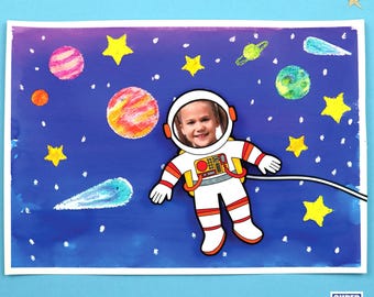 May include: A child's face is visible through the helmet of a white astronaut cutout. The astronaut is floating in a blue and purple space scene with yellow stars, planets, and a comet.