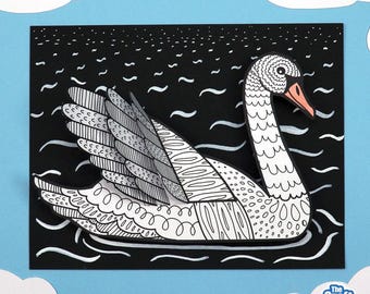 May include: A paper craft swan with intricate black and white patterns on its body and wings, featuring an orange beak. The swan is layered over a black background with white wavy lines representing water. The text The Craft Train is visible.