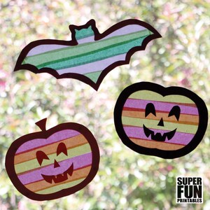 May include: Three Halloween window clings, a bat and two pumpkins, made from colourful striped tissue paper. The bat is green and white, and the pumpkins are orange, yellow, pink, and red.