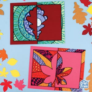 May include: Two rectangular paper cards featuring intricate leaf-themed artwork. The top card displays a dark red oak leaf silhouette against a green and blue patterned background. The bottom card shows a pink maple leaf design with geometric patterns.