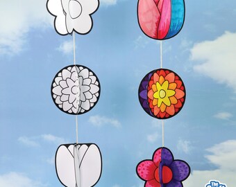 May include: Paper flower decorations in various shapes and colors, hanging against a blue sky background. The decorations include a white flower, a pink and blue tulip, a black and white flower, a colorful flower, and a purple and red flower.