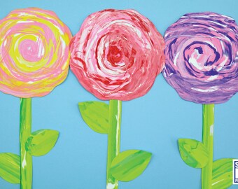 May include: Three paper flowers with swirled paint designs. The flowers are yellow, pink, and purple. The flowers are on green stems with leaves.