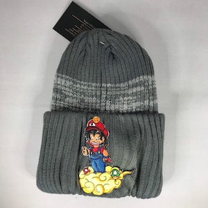 May include: Gray knit beanie with a white stripe and a cartoon character wearing a red hat and blue overalls on a yellow cloud.