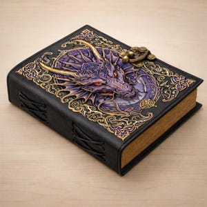 May include: A black leather journal with a detailed dragon design on the cover. The dragon is purple and gold, with red eyes. The journal has a clasp closure and decorative gold accents. The edges of the pages are gold.