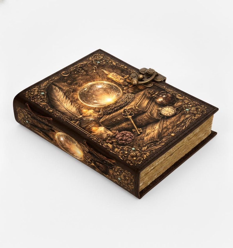 May include: A brown leather-bound journal with intricate embossed designs. The cover features a crystal ball, key, clock, and feather, with a metal clasp. The edges of the pages are gold-toned, and the overall aesthetic is vintage and ornate.