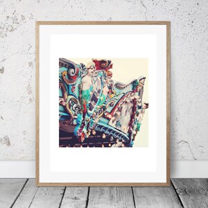 May include: A vintage carousel horse with a blue, green, red, and gold paint scheme. The horse is decorated with intricate details and has a whimsical, fairytale-like appearance.