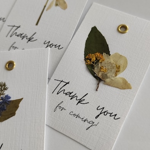 Personalisierte flache Dankeschön-Tags mit echten Blumen. Anhänger mit gepressten Blumen. Danke für kommende Karte mit Wiesenblumen