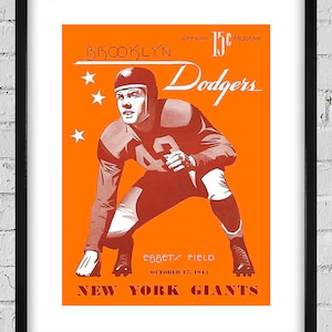 Może przedstawiać: Winietkowy program Brooklyn Dodgers z 17 października 1943 roku na mecz przeciwko New York Giants na Ebbets Field. Program jest w kolorze pomarańczowym i czerwonym i zawiera rysunkową ilustrację piłkarza w czerwonym stroju.