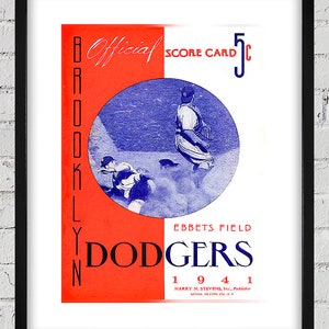 May include: A vintage red and blue baseball scorecard for the Brooklyn Dodgers. The scorecard features a photo of two baseball players in action. The text on the scorecard reads "Official Score Card 5c" and "Ebbets Field Dodgers 1941".