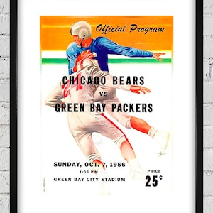 May include: Framed vintage football program poster featuring the Chicago Bears vs. Green Bay Packers. The artwork depicts two players in action, with text including the date, time, and stadium. The poster has a black frame and is displayed against a white brick wall.