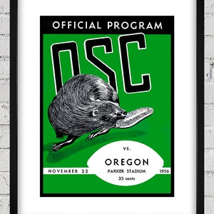 Op de afbeelding: Een groen en wit vintage programma voor een voetbalwedstrijd tussen Oregon State en Oregon. Het programma toont een cartoonbever en de tekst "OFFICIAL PROGRAM OSC VS. OREGON PARKER STADIUM NOVEMBER 22 1956 35 cents".
