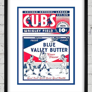 Könnte beinhalten: Gerahmtes Vintage-Baseball-Poster mit den Chicago Cubs. Das Poster hat ein rot-weiß-blaues Farbschema mit dem Text "CUBS" und "Wrigley Field". Es enthält auch Baseballspieler und den Text "Blue Valley Butter".