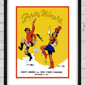 Può includere: Poster vintage incorniciato con sfondo giallo e bordo rosso. Il poster presenta due personaggi dei cartoni animati e il testo "Forty Niners vs. New York Yankees, September 8, 1946." Il prezzo è di 25c. L'opera è in una cornice nera.
