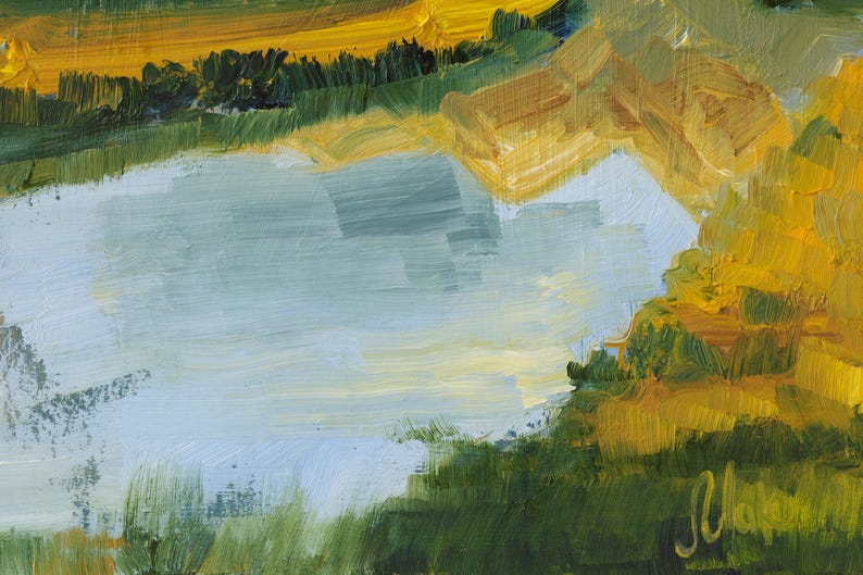 May include: An oil painting on canvas depicting a landscape with a central light blue body of water surrounded by textured brushstrokes of yellow, gold, and deep green foliage. A signature in cursive yellow paint is visible in the bottom right corner.
