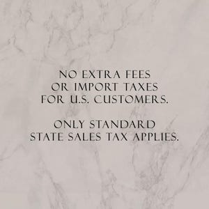 May include: A light beige marble-textured background with black text that reads: NO EXTRA FEES OR IMPORT TAXES FOR U.S. CUSTOMERS. ONLY STANDARD STATE SALES TAX APPLIES. The text is centered and written in a clean, sans-serif, uppercase font style.