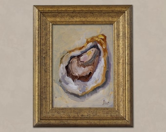 May include: Oil painting of an oyster shell in a gold frame. The oyster is painted with shades of brown, white, and purple. The frame is a detailed gold color. The artwork is on a light beige background.