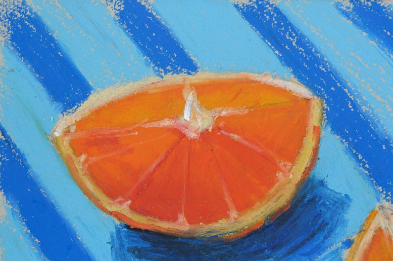 May include: A close-up of a bright orange orange slice on a blue and white striped background. The orange slice is cut in half and shows the segments of the fruit.