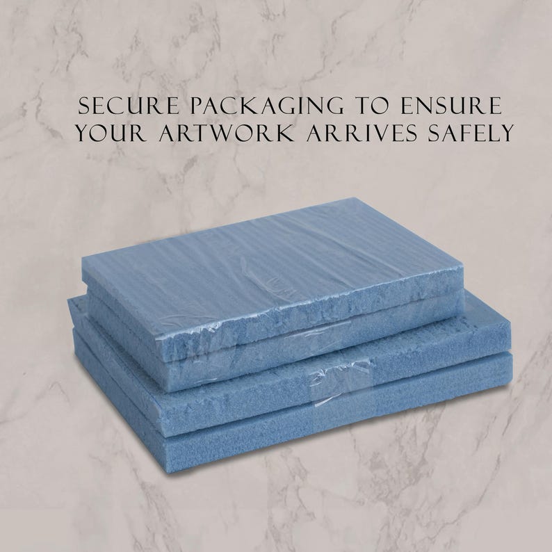 May include: Two rectangular blue foam blocks stacked on top of each other, wrapped in clear plastic film. The text SECURE PACKAGING TO ENSURE YOUR ARTWORK ARRIVES SAFELY is printed in black above the stacked foam blocks on a light marble background.