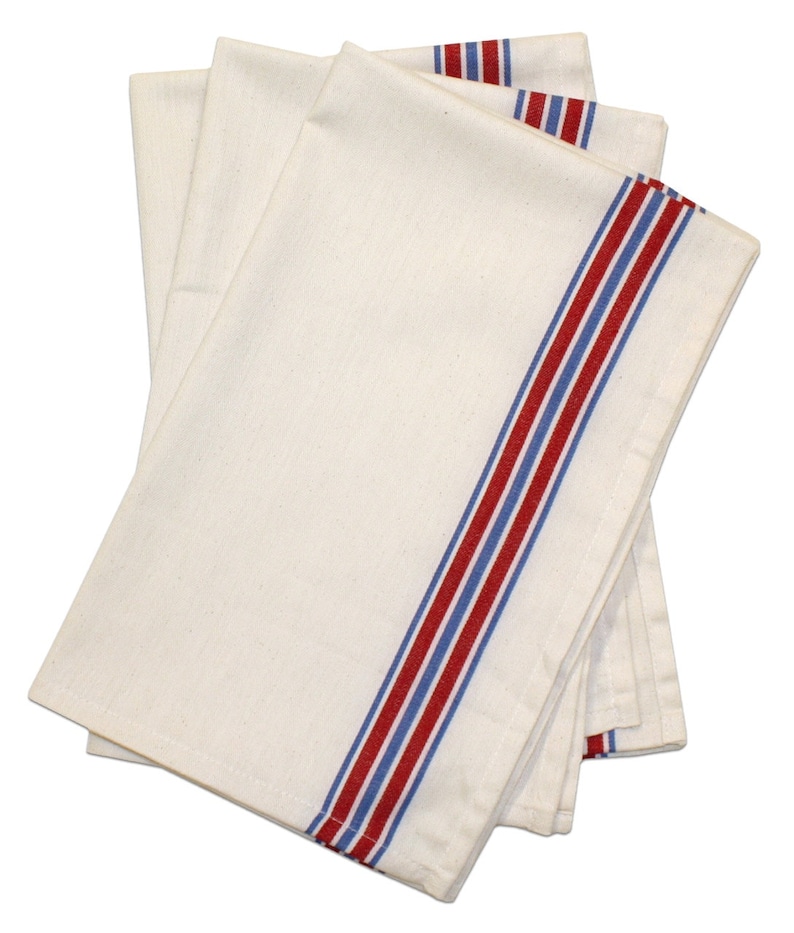 May include: A stack of three white kitchen towels with red and blue stripes along the edge.