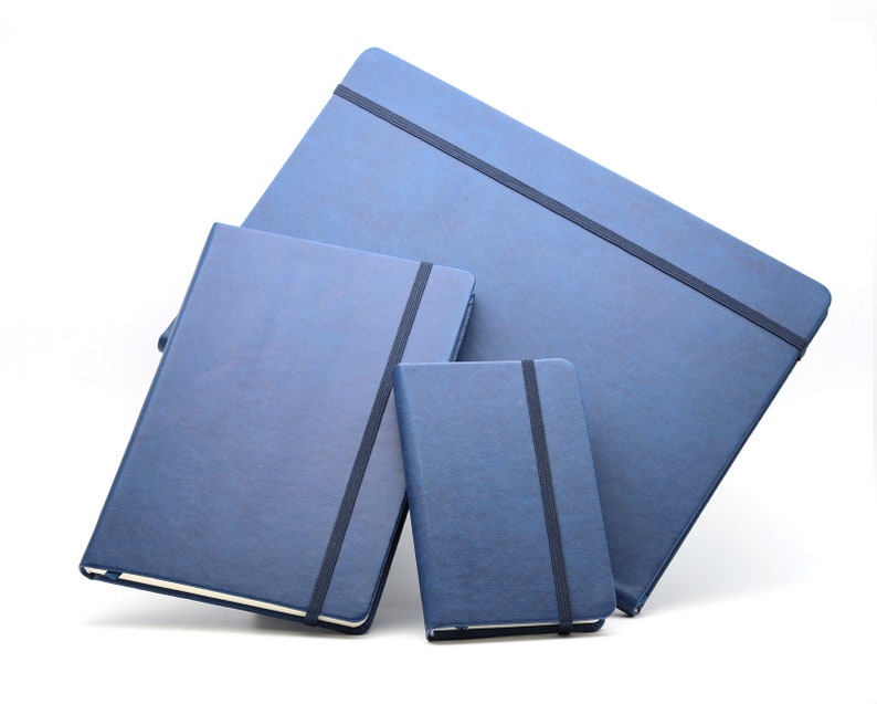 May include: Three blue notebooks of different sizes, each with a black elastic band closure. The notebooks are stacked on top of each other.