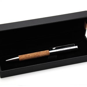 May include: A ballpoint pen with a natural cork grip and a polished silver-tone metal cap and tip. The cap features the engraved name Sophia Scott. The pen is presented inside a rectangular black gift box with a textured exterior and black lining.
