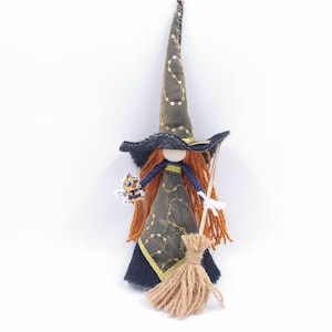 May include: A handmade witch doll with a black and green dress, a black pointed hat with gold accents, and a brown broom. The doll has long red hair and is holding a small bee figurine.