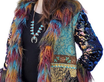May include: A long, colourful, faux fur coat with a sequined sleeve. The coat is made of different fabrics and textures, including velvet, brocade, and sequins. The coat has a turquoise and brown necklace with a crescent moon pendant.