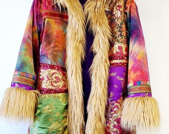 May include: A vibrant, hooded coat with faux fur trim and cuffs. The coat has a tie-dye design with green, purple, and gold fabric patches. The hood is purple with gold embroidery, and the faux fur is light brown.