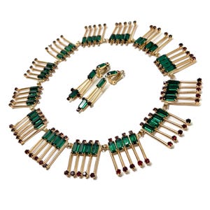 May include: A vintage jewelry set featuring a necklace and matching earrings. The necklace and earrings have a gold-tone metal base with emerald green and ruby red colored rhinestones. The necklace is a collar style.