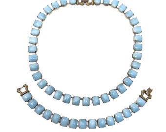 May include: A vintage jewelry set featuring a necklace and bracelet. The set is composed of light blue, rectangular stones set in a gold-toned metal. The necklace and bracelet have matching clasps.