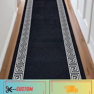 May include: A long, rectangular runner rug featuring a solid black center and two white borders decorated with a repeating geometric Greek key pattern. The rug is positioned lengthwise, extending from the foreground toward the background.