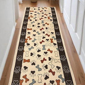 May include: Beige runner rug with a repeating pattern of dog bones and paw prints in brown, black, and blue. The rug has a dark brown border with paw print designs. Ideal for a hallway or entryway.