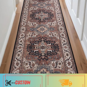 May include: A long rectangular runner rug featuring a repeating ornate medallion pattern in shades of terracotta, charcoal gray, and cream. The rug has a dark border and is positioned lengthwise, displaying a symmetrical design across its entire surface.