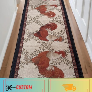 May include: A long rectangular runner rug featuring a repeating pattern of rust-colored roosters set against a light beige background with a delicate vine motif. The rug is framed by a dark black border with a thin red geometric accent line.