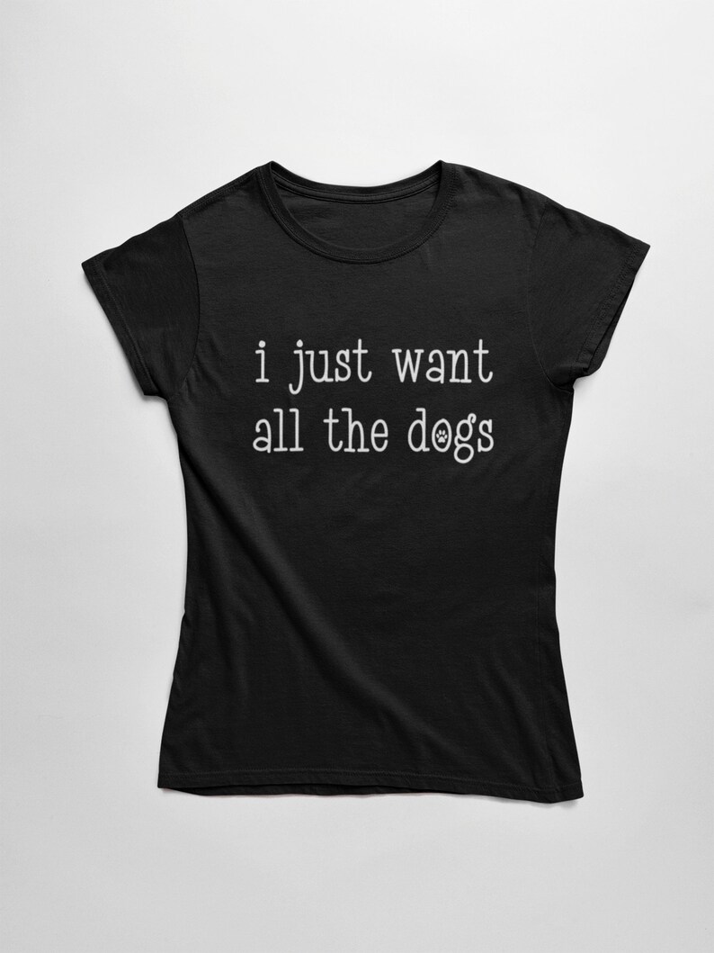 May include: Black t-shirt with the white text "i just want all the dogs". The text includes a paw print in place of the letter "o" in "dogs". The shirt is made of a soft material and has short sleeves.