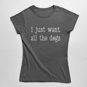 May include: A dark grey t-shirt featuring the white text "i just want all the dogs". The word "dogs" is replaced with a paw print. The top has a crew neck and short sleeves.