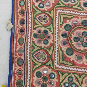 Puede incluir: Un tapiz de pared textil colorido con bordados intrincados y adornos de espejo. El dise&ntilde;o presenta motivos florales y patrones geom&eacute;tricos en tonos rojos, verdes, azules y amarillos.