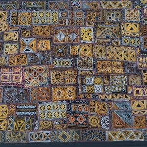 May include: A colorful patchwork quilt with intricate embroidery in shades of gold, brown, and white. The quilt is made up of many small squares and rectangles, each with a different design. The quilt is framed with a black border.