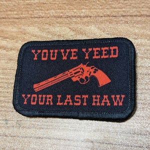 May include: Black and red embroidered patch with the text "You've Yee'd Your Last Haw" and a red silhouette of a revolver.