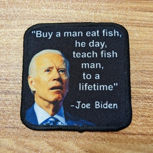 May include: A black and white embroidered patch with a quote by Joe Biden: "Buy a man eat fish, he day, teach fish man, to a lifetime."