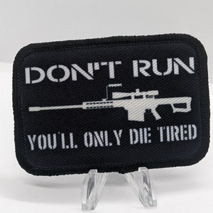 May include: Black and white patch with the text "DON'T RUN YOU'LL ONLY DIE TIRED" and a silhouette of a rifle with a scope.