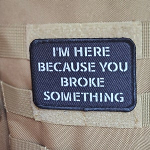 Peut inclure: Patch noir avec du texte blanc qui dit "Je suis là parce que tu as cassé quelque chose."
