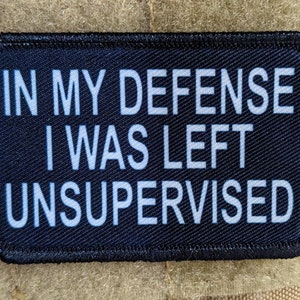 Könnte beinhalten: Schwarzer Patch mit weißem Text, der "In meiner Verteidigung war ich unbeaufsichtigt" lautet.