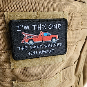 May include: Black and white patch with a red tow truck and the text "I'm the one the bank warned you about".